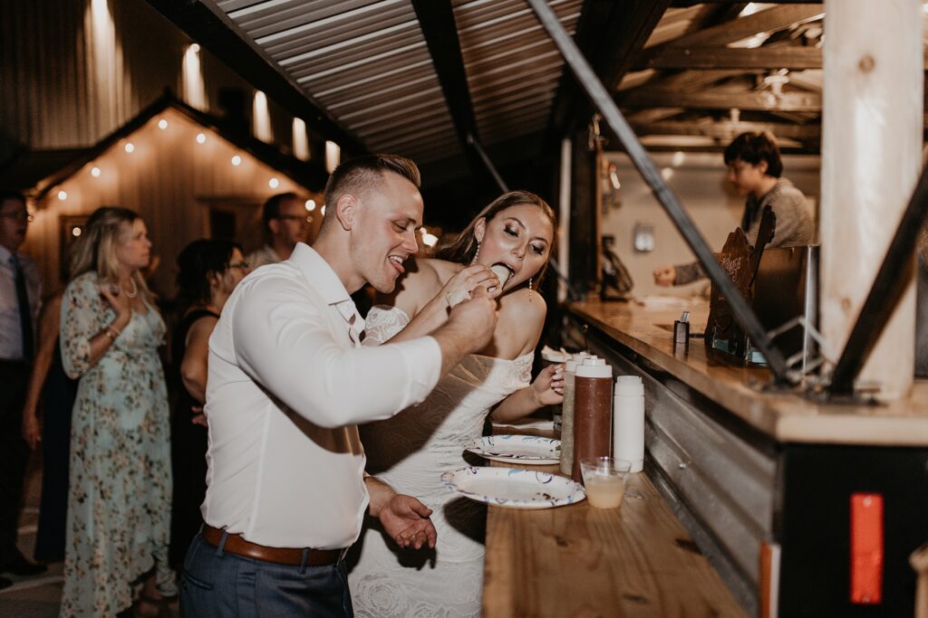 Bride and Groom eating tacos outside their reception.