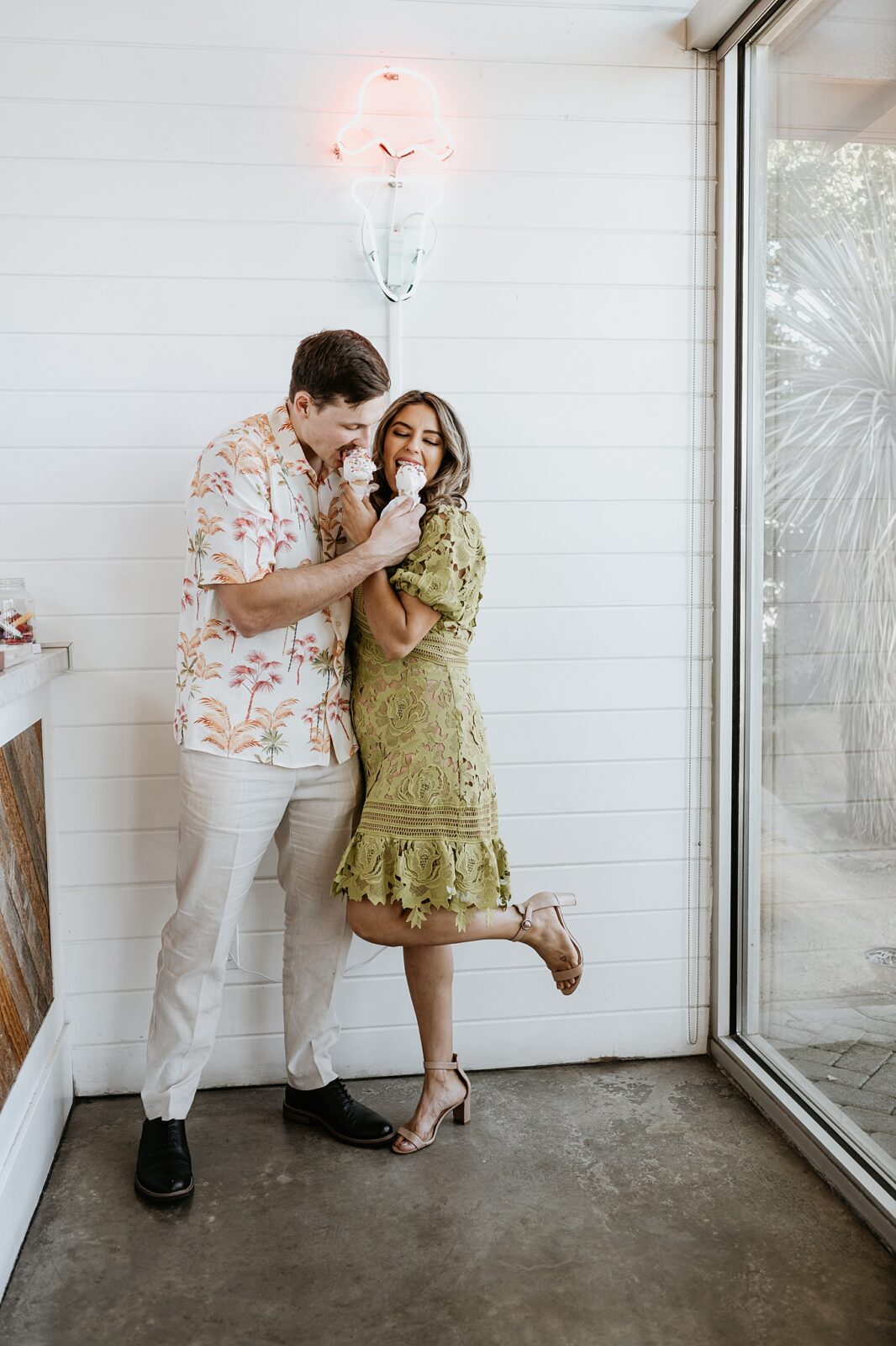 Couple sharing ice cream cone arms crossed around one another