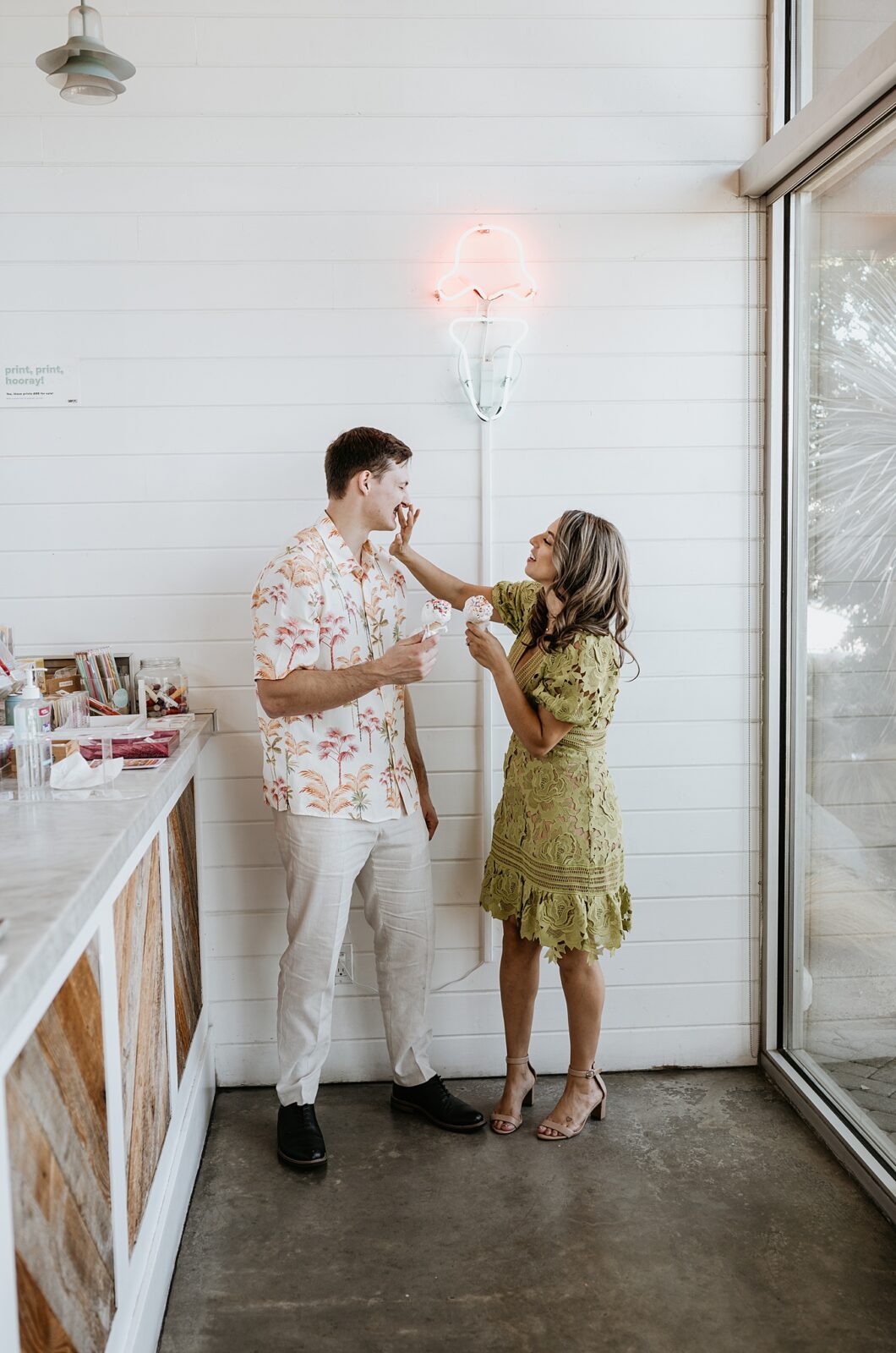 Girl is wiping ice cream off of guy's face