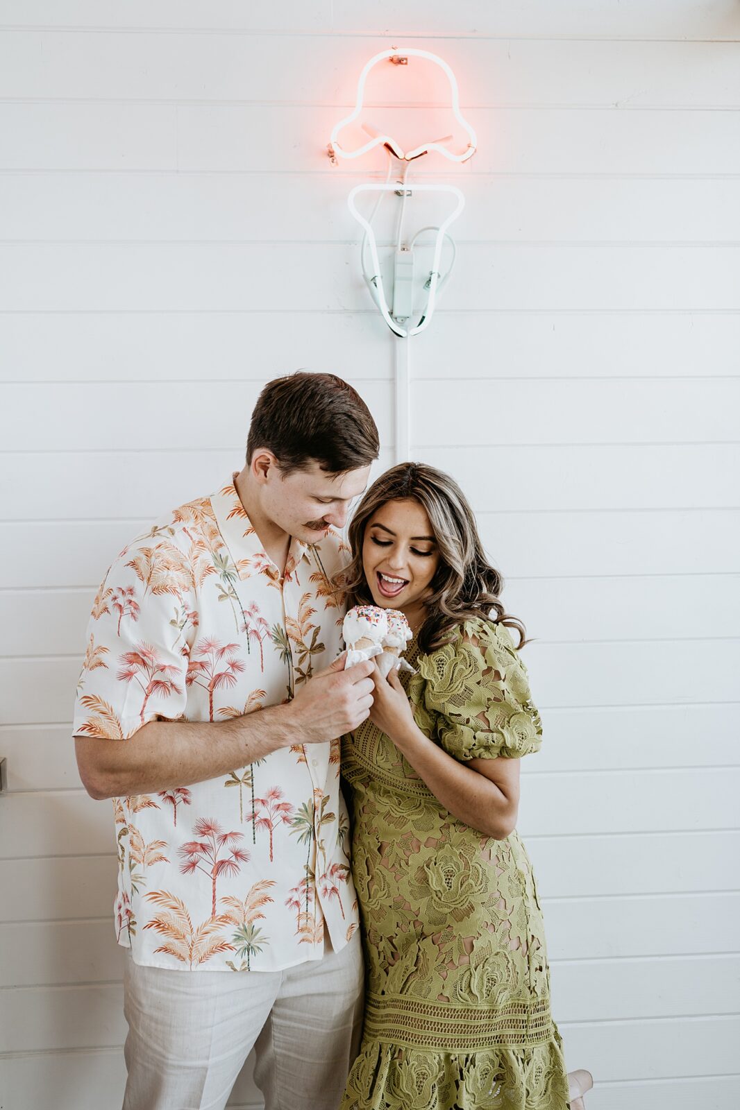 Couple looking down at their ice cream cones smiling