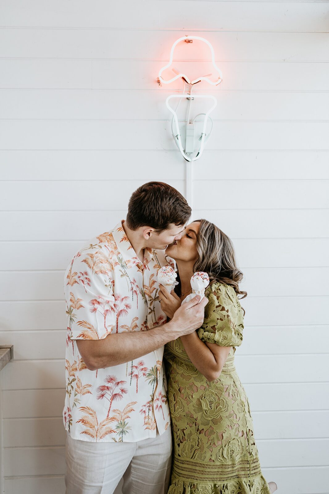 Couple is kissing while holding their ice cream inside a Palm Springs ice cream shop