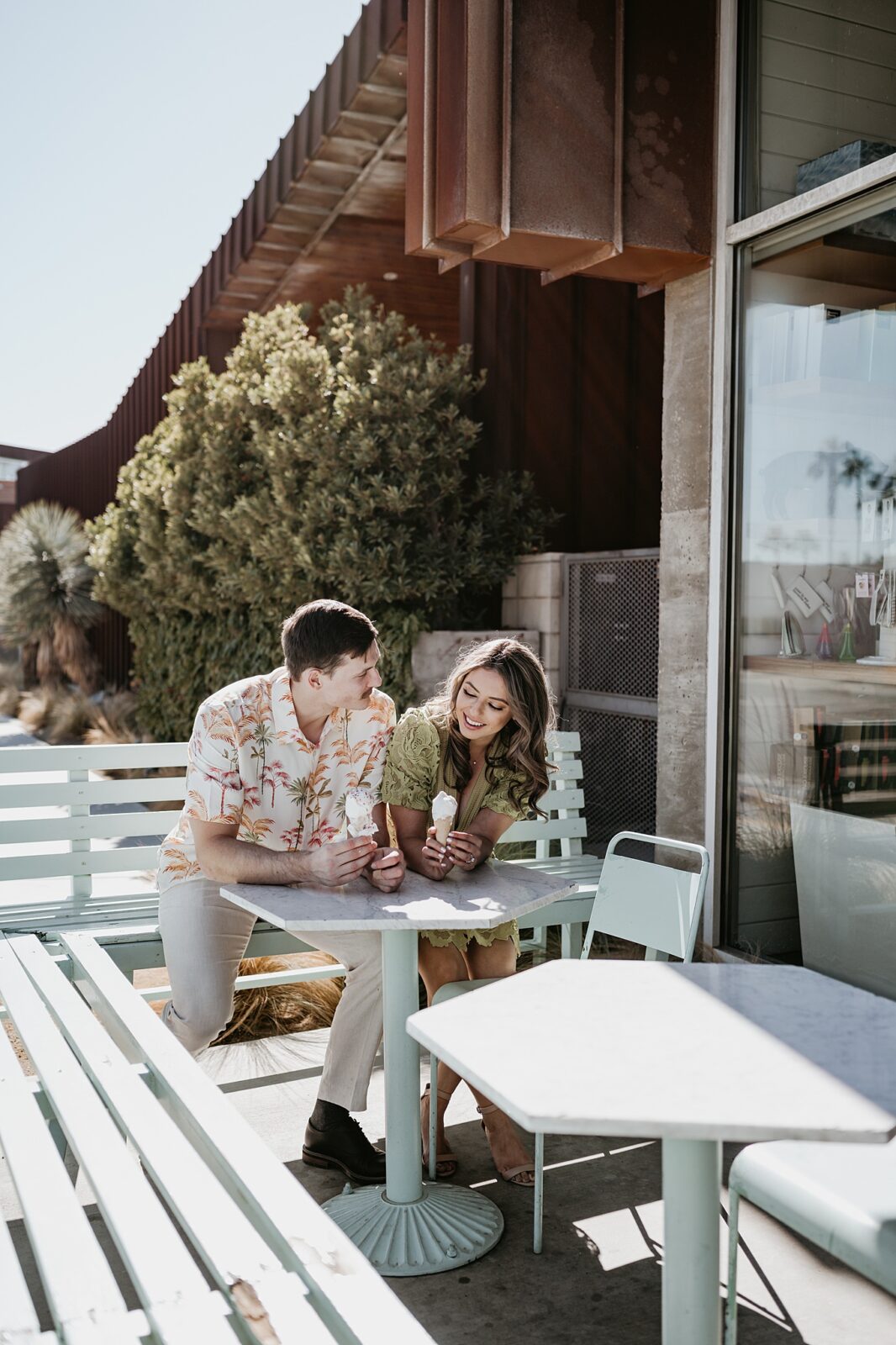 Couple is sitting at a table outside a Palm Springs ice cream shop