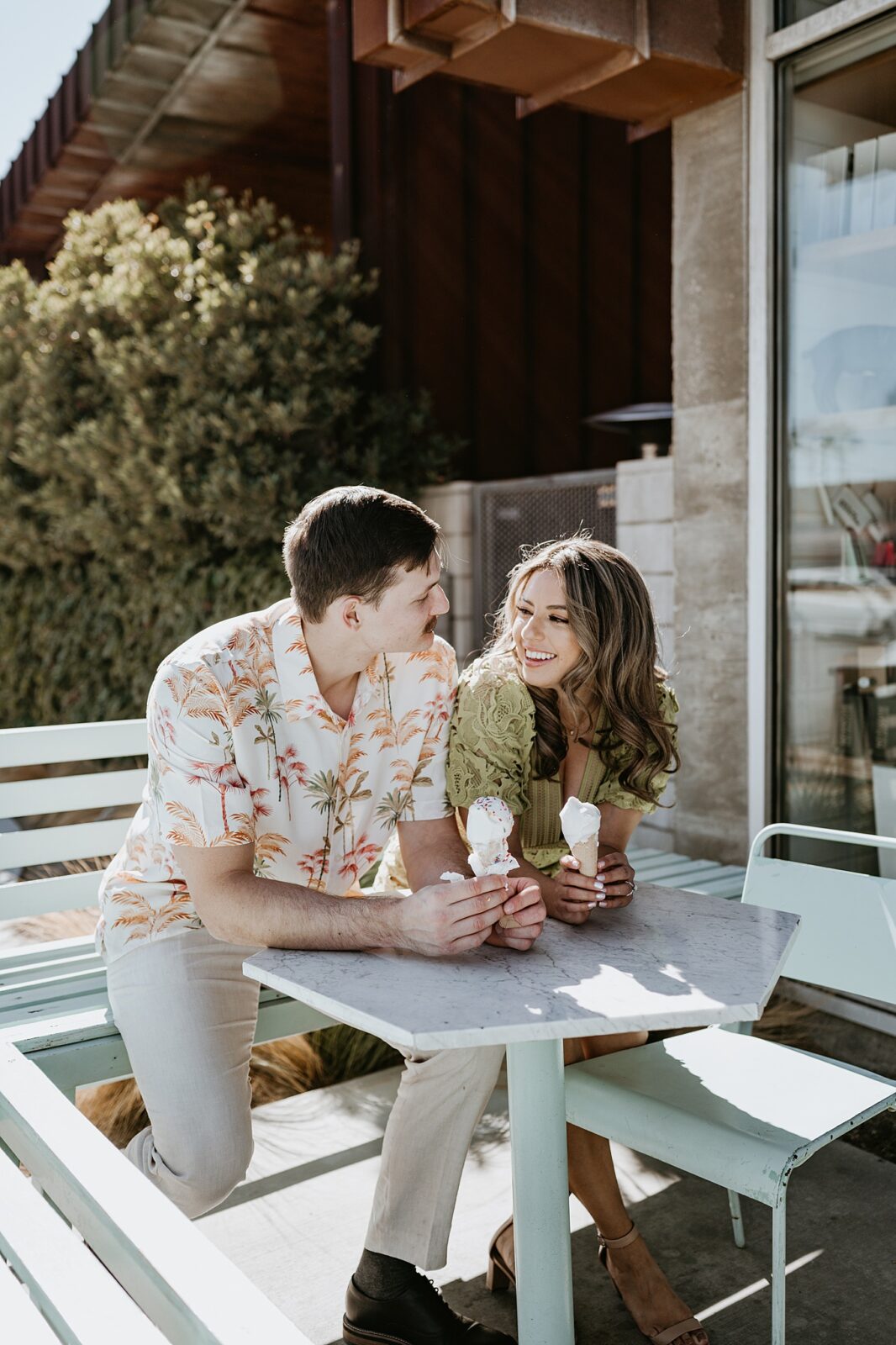 Couple sitting outside at a table smiling and laughing