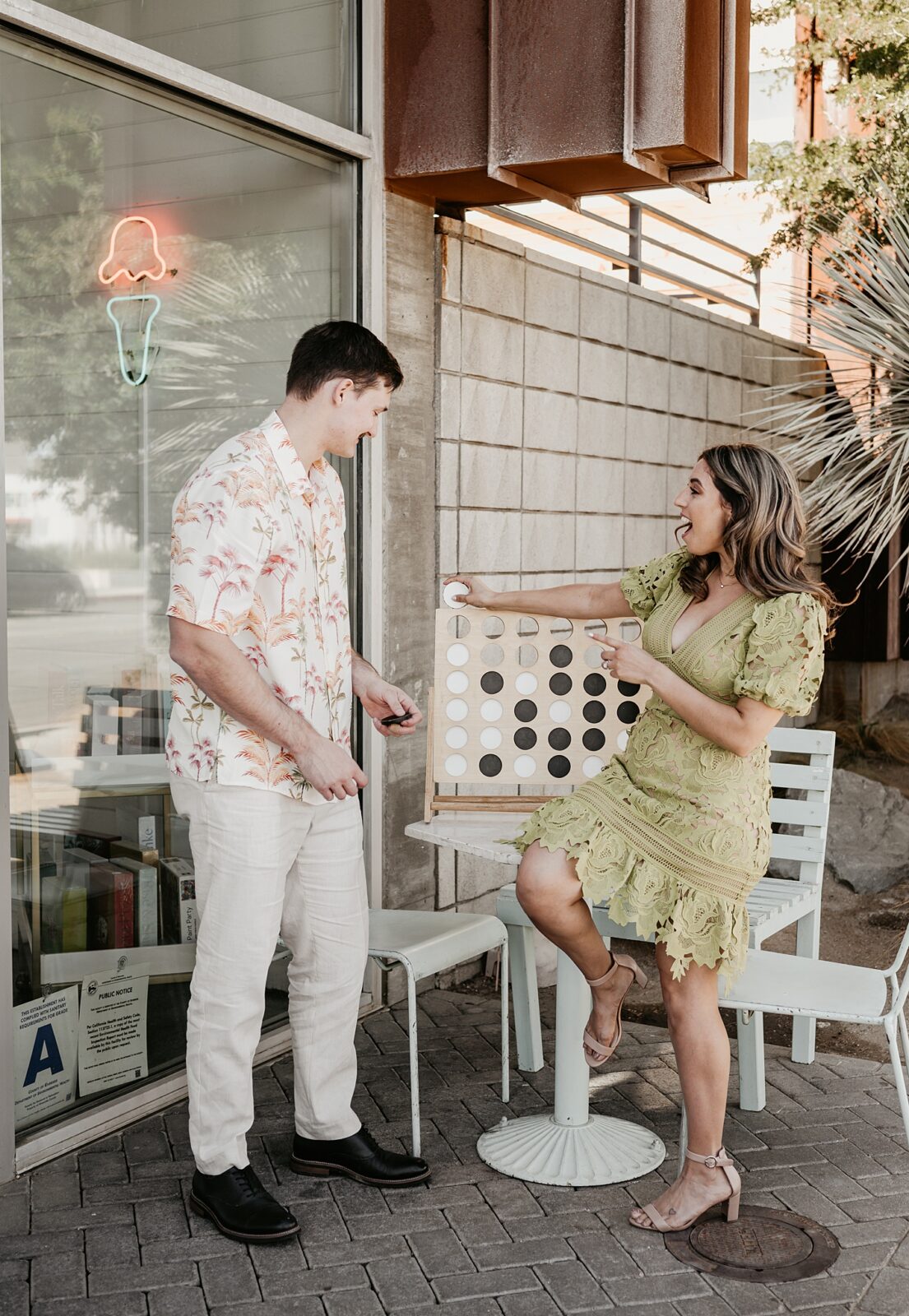 Couple laughing while playing a giant connect four game