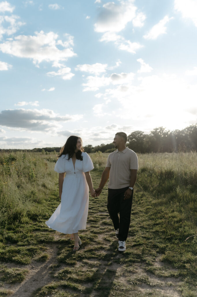 A couple walking and laughing together to create authentic engagement photos with natural movement.