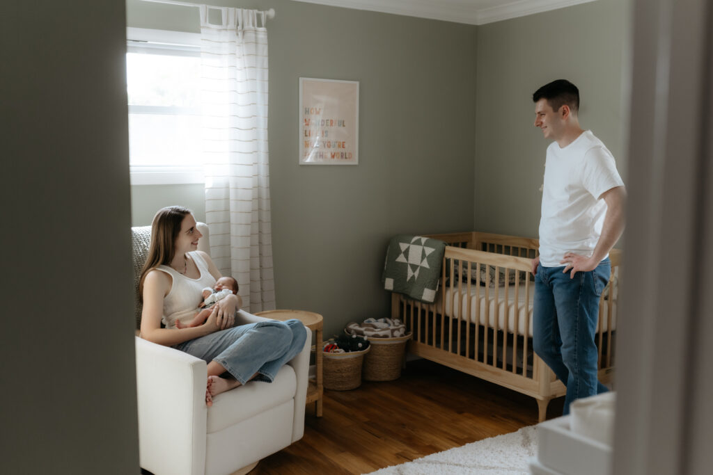 In-home newborn session showing authentic connection on a neutral setting