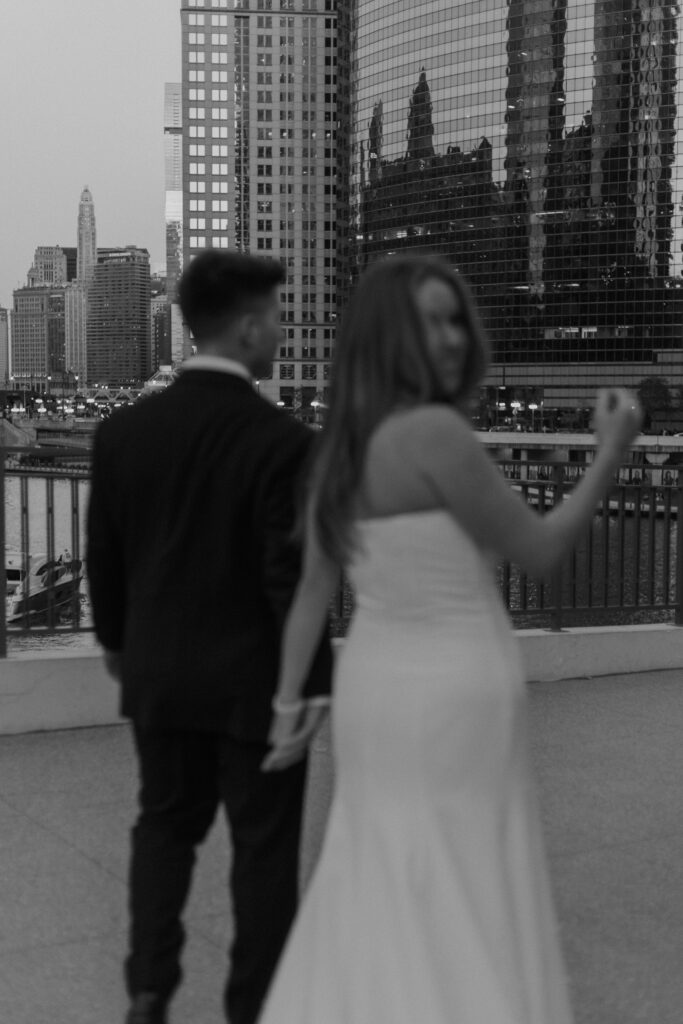 An artistic motion blur photograph of a bride looking over her shoulder while walking away.