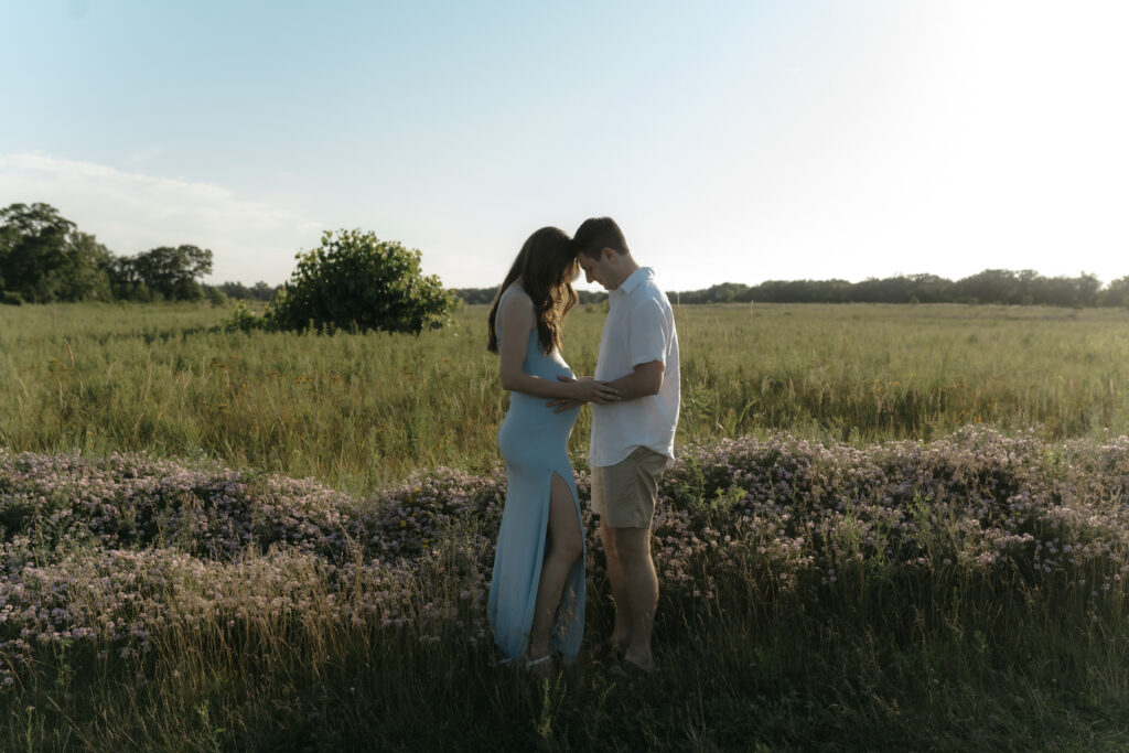 A couple touches foreheads in a vast meadow, creating a peaceful space to feel comfortable in front of the camera.