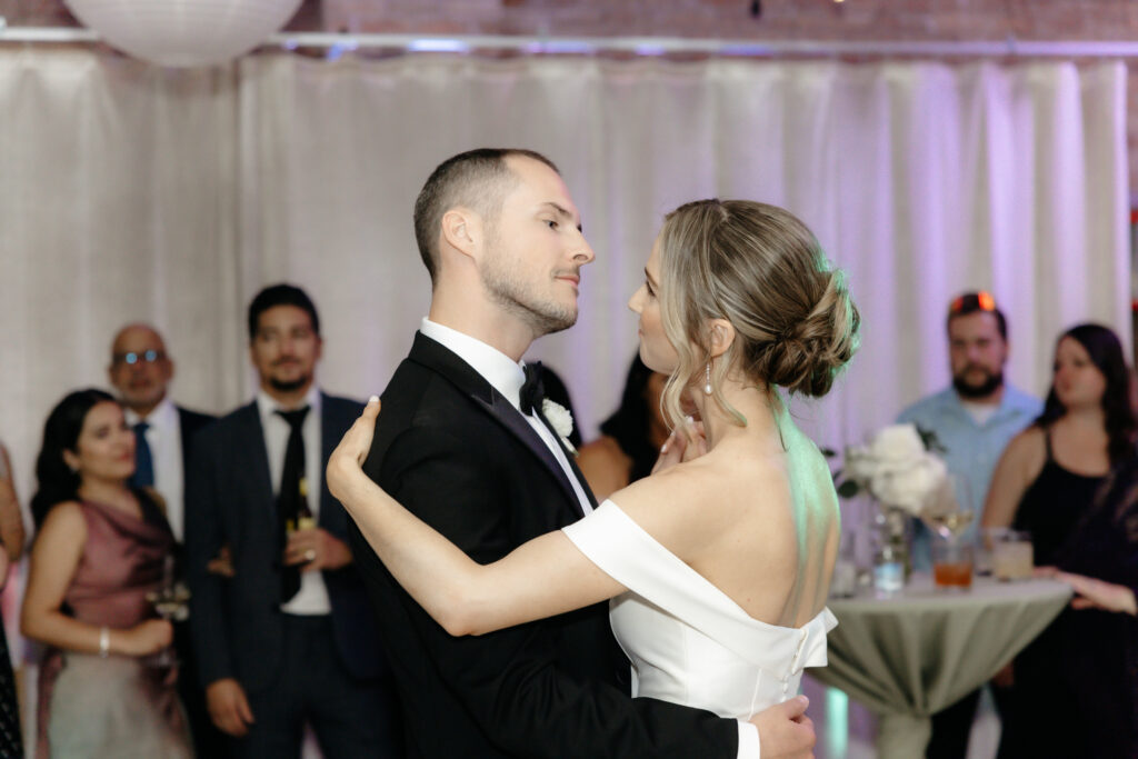 Intimate close-up of a bride and groom embracing during their first dance at a wedding reception.